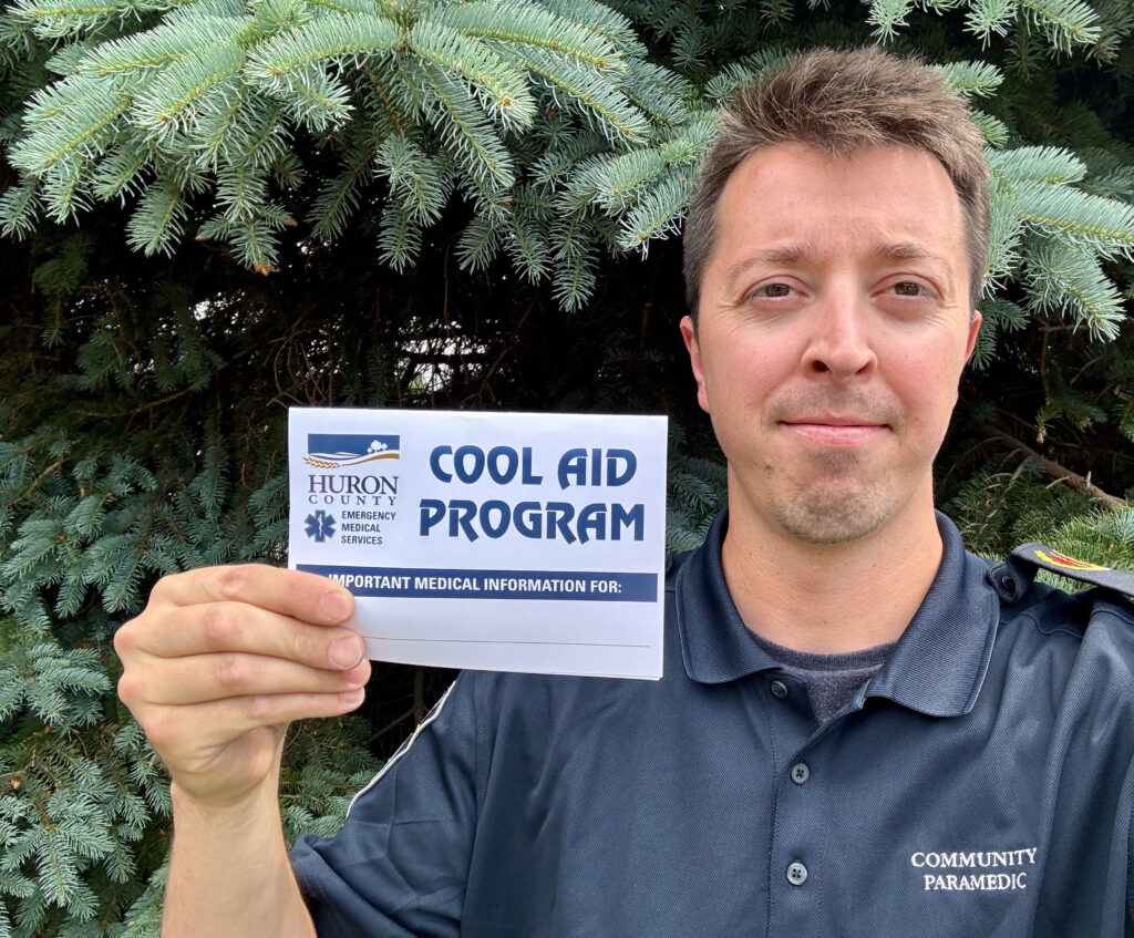 a male paramedic holding a Cool Aid card